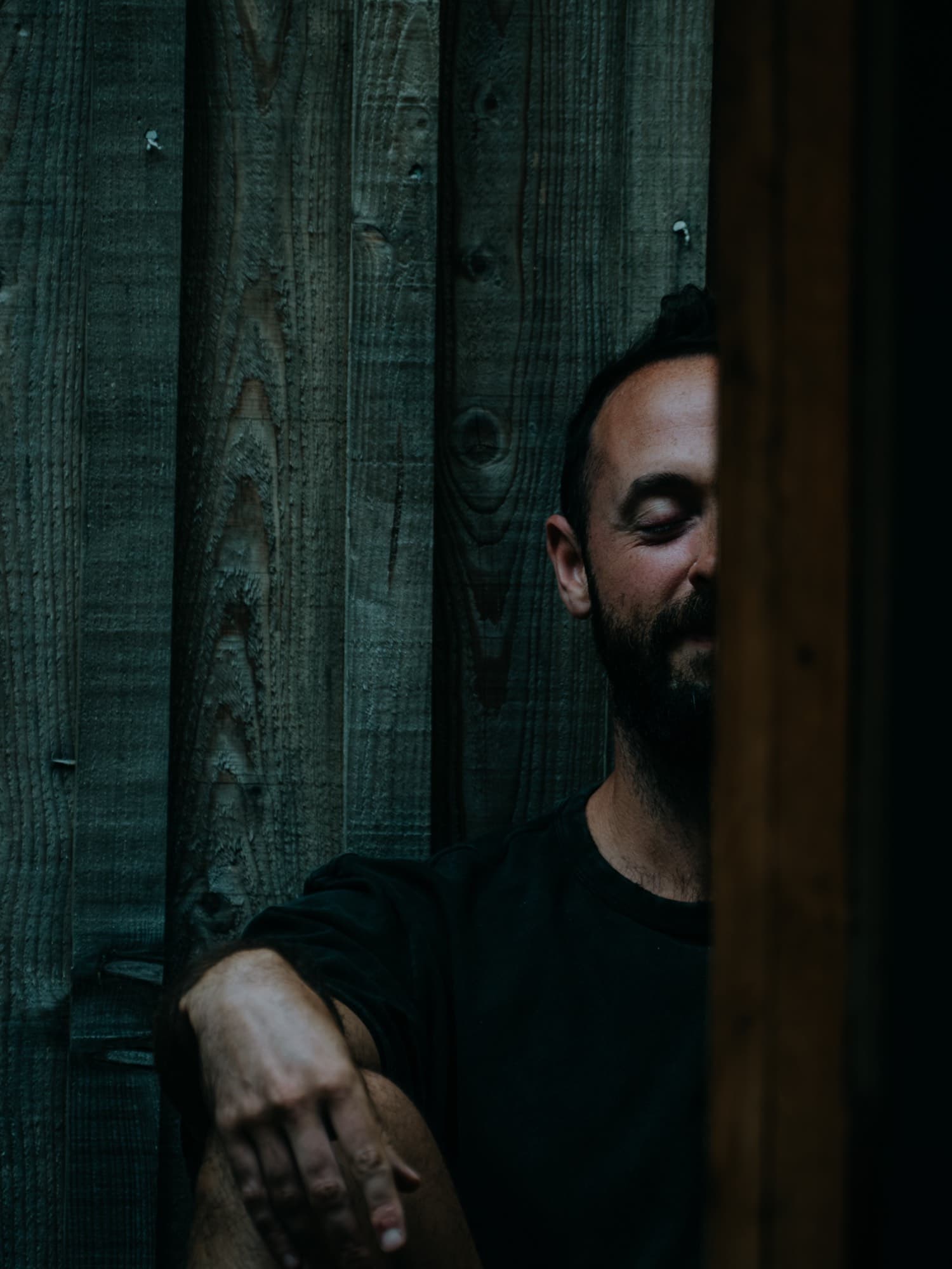 A participant standing alone against a timber wall